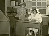 Ward clerk consulting charge nurse at Grasslands Hospital, ca. 1950 (P-552). 